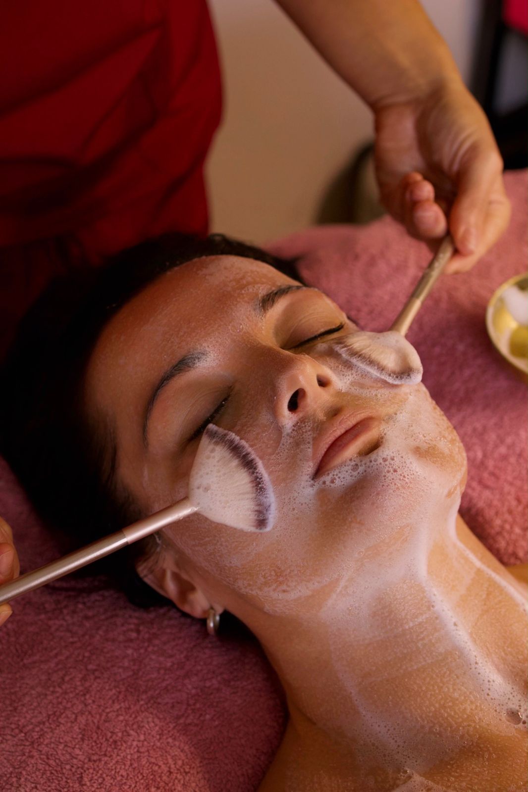 Beauty therapist giving a client a facial treatment