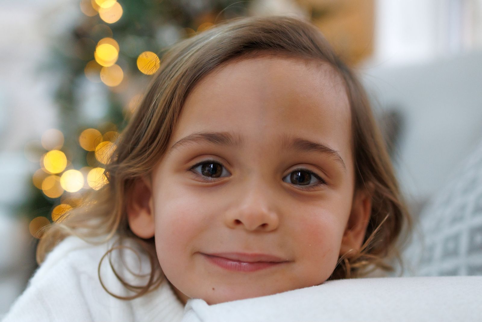 Smiling little girl in front of the Christmas tree