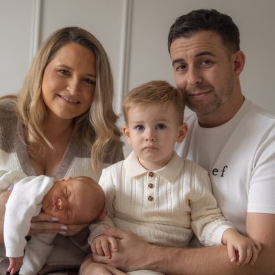 Family of four with their newborn on the sofa